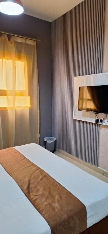 Bedroom with flat-screen TV and city-facing window